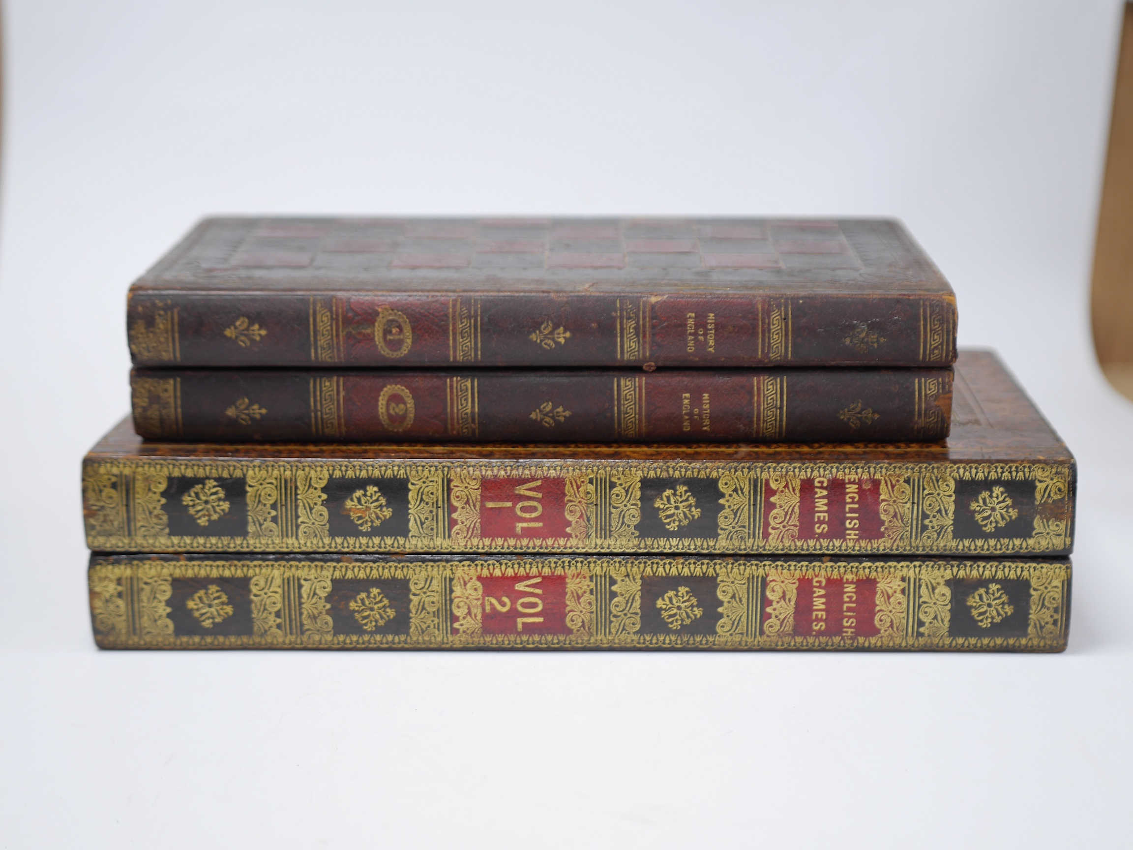 Two Victorian leather bound folding games compendium boards, both as mock bindings; English Games & History of England, with a set of bone draughtsmen. Condition - fair